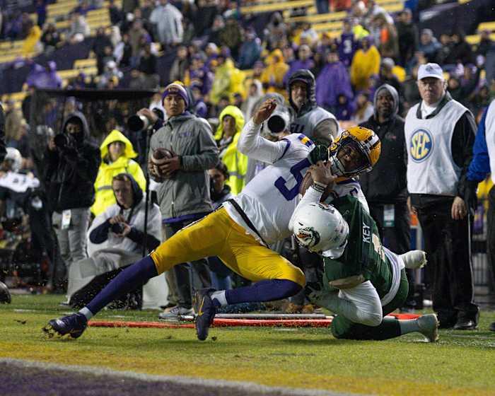 LSU Tigers quarterback Jayden Daniels (5) is tackled out of bounds by UAB Blazers safety Jaylen Key (1) and flagged for a course collar tackle during the second half at Tiger Stadium.